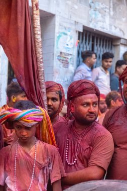 Barsana, Uttar Pradesh, Hindistan - 18 Mart 2024: Geleneksel giysiler ve rengarenk yüzlü Hindu erkek grubu, Barsana 'nın Rangili Gali' sindeki lathmar Holi 'yi geleneksel olarak kutluyorlar..