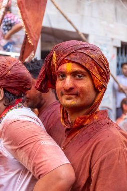 Barsana, Uttar Pradesh, Hindistan - 18 Mart 2024: Geleneksel giysiler ve rengarenk yüzlü Hindu erkek grubu, Barsana 'nın Rangili Gali' sindeki lathmar Holi 'yi geleneksel olarak kutluyorlar..