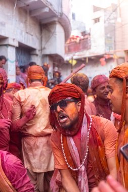 Barsana, Uttar Pradesh, Hindistan - 18 Mart 2024: Geleneksel giysiler ve rengarenk yüzlü Hindu erkek grubu, Barsana 'nın Rangili Gali' sindeki lathmar Holi 'yi geleneksel olarak kutluyorlar..