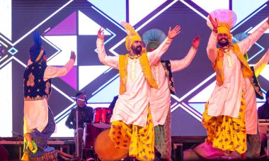 Bikaner, Rajasthan, Hindistan - 14 Ocak 2023: Haryana 'lı bir grup erkek sanatçı, bikaner deve festivalinde geleneksel renkli giysiler içinde geleneksel halk dansları yapıyor.