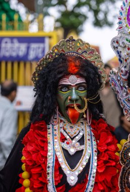Varanasi, Uttar Pradesh, Hindistan - 20 Mart 2024: Masan Holi, Masan Holi, Masan Holi, Harishchandra ghat 'taki masaan holi kutlamaları sırasında tanrıça Kali olarak resmedilen bir kadın ressamın portresi.