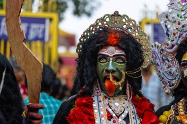 Varanasi, Uttar Pradesh, Hindistan - 20 Mart 2024: Masan Holi, Masan Holi, Masan Holi, Harishchandra ghat 'taki masaan holi kutlamaları sırasında tanrıça Kali olarak resmedilen bir kadın ressamın portresi.