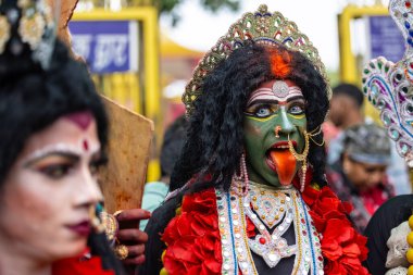 Varanasi, Uttar Pradesh, Hindistan - 20 Mart 2024: Masan Holi, Masan Holi, Masan Holi, Harishchandra ghat 'taki masaan holi kutlamaları sırasında tanrıça Kali olarak resmedilen bir kadın ressamın portresi.