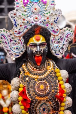 Varanasi, Uttar Pradesh, Hindistan - 20 Mart 2024: Masan Holi, Masan Holi, Masan Holi, Harishchandra ghat 'taki masaan holi kutlamaları sırasında tanrıça Kali olarak resmedilen bir kadın ressamın portresi