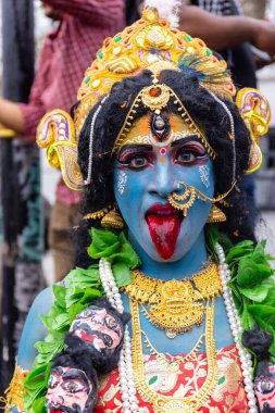 Varanasi, Uttar Pradesh, Hindistan - 20 Mart 2024: Masan Holi, Masan Holi, Masan Holi, Harishchandra ghat 'taki masaan holi kutlamaları sırasında tanrıça Kali olarak resmedilen bir kadın ressamın portresi