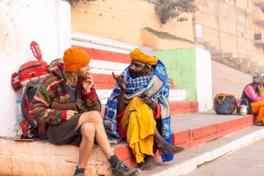 Varanasi, Uttar Pradesh, Hindistan - 20 Ocak 2024: Varanasi 'deki çetelerin yakınındaki ghat üzerinde geleneksel bir sadhu baba resmi. Sadhu, Kaşhi 'de Ganga yakınlarında ayinler düzenler..