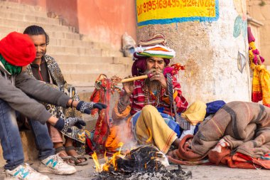 Varanasi, Uttar Pradesh, Hindistan - 20 Ocak 2024: Varanasi 'deki çetelerin yakınındaki ghat üzerinde geleneksel bir sadhu baba resmi. Sadhu, Kaşhi 'de Ganga yakınlarında ayinler düzenler..