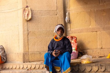 Varanasi, Uttar Pradesh, Hindistan - 20 Ocak 2024: Varanasi 'deki çetelerin yakınındaki ghat üzerinde geleneksel bir sadhu baba resmi. Sadhu, Kaşhi 'de Ganga yakınlarında ayinler düzenler..