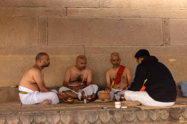 Varanasi, Uttar Pradesh, Hindistan - 20 Ocak 2024: Varanasi 'deki çetelerin yakınlarındaki ghat üzerinde tanımlanamayan brahmin erkek shraadh ayinleri düzenliyor.