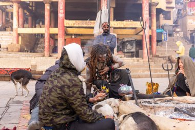 Varanasi, Uttar Pradesh, Hindistan - 20 Ocak 2024: Yanmış kemikleri toplamak ve Hindu ayini olarak Harishchandra ghat 'ta cesetleri yakmak için alanı temizlemek için Hint erkek işçi grubu.