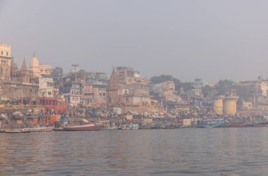 Varanasi, Uttar Pradesh, Hindistan - 20 Ocak 2024: Varanasi 'deki nehir çetelerinin yakınındaki ghatların mimari görüşü ve tapınakları. Ganga nehrinde yüzen tekneden binaların görüntüsü.