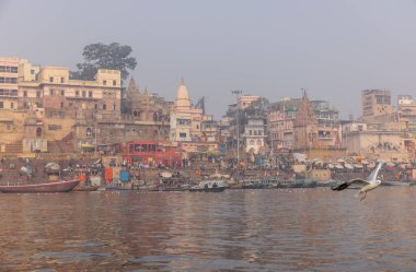 Varanasi, Uttar Pradesh, Hindistan - 20 Ocak 2024: Varanasi 'deki nehir çetelerinin yakınındaki ghatların mimari görüşü ve tapınakları. Ganga nehrinde yüzen tekneden binaların görüntüsü.