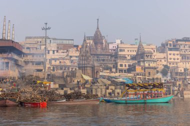 Varanasi, Uttar Pradesh, Hindistan - 20 Ocak 2024: Varanasi 'deki nehir çetelerinin yakınındaki ghatların mimari görüşü ve tapınakları. Ganga nehrinde yüzen tekneden binaların görüntüsü.