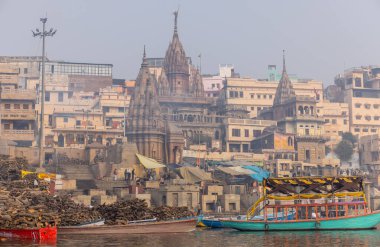 Varanasi, Uttar Pradesh, Hindistan - 20 Ocak 2024: Varanasi 'deki nehir çetelerinin yakınındaki ghatların mimari görüşü ve tapınakları. Ganga nehrinde yüzen tekneden binaların görüntüsü.