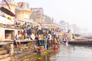 Varanasi, Uttar Pradesh, Hindistan - 20 Ocak 2024: Varanasi 'deki nehir çetelerinin yakınındaki ghatların mimari görüşü ve tapınakları. Ganga nehrinde yüzen tekneden binaların görüntüsü.
