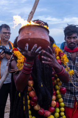 Kulashekharapatnam, Tamilnadu, Hindistan - 11 Ekim 2024: Hint Hindu dindar, yüzü boyalı ve tarikat karakteri gibi giyinmiş, kulasai dasara festivalini akşam ateşle gerçekleştirmek için.