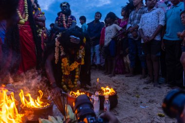 Kulashekharapatnam, Tamilnadu, Hindistan - 11 Ekim 2024: Hint Hindu dindar, yüzü boyalı ve tarikat karakteri gibi giyinmiş, kulasai dasara festivalini akşam ateşle gerçekleştirmek için.