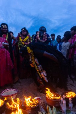 Kulashekharapatnam, Tamilnadu, Hindistan - 11 Ekim 2024: Hint Hindu dindar, yüzü boyalı ve tarikat karakteri gibi giyinmiş, kulasai dasara festivalini akşam ateşle gerçekleştirmek için.