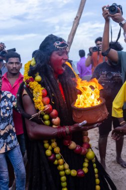 Kulashekharapatnam, Tamilnadu, Hindistan - 11 Ekim 2024: Hint Hindu dindar, yüzü boyalı ve tarikat karakteri gibi giyinmiş, kulasai dasara festivalini akşam ateşle gerçekleştirmek için.