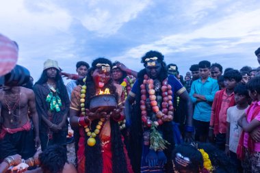 Kulashekharapatnam, Tamilnadu, Hindistan - 11 Ekim 2024: Hint Hindu dindar, yüzü boyalı ve tarikat karakteri gibi giyinmiş, kulasai dasara festivalini akşam ateşle gerçekleştirmek için.