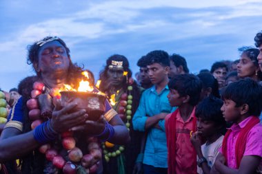 Kulashekharapatnam, Tamilnadu, Hindistan - 11 Ekim 2024: Hint Hindu dindar, yüzü boyalı ve tarikat karakteri gibi giyinmiş, kulasai dasara festivalini akşam ateşle gerçekleştirmek için.