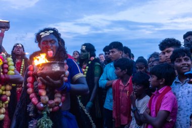 Kulashekharapatnam, Tamilnadu, Hindistan - 11 Ekim 2024: Hint Hindu dindar, yüzü boyalı ve tarikat karakteri gibi giyinmiş, kulasai dasara festivalini akşam ateşle gerçekleştirmek için.