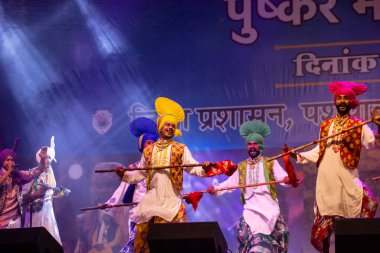 Bikaner, Rajasthan, Hindistan - 14 Ocak 2023: Punjab 'dan bir grup Punjab sanatçısı bikaner deve festivalinde geleneksel renkli elbiseler içinde bhangra dansı yapıyorlar.
