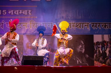 Bikaner, Rajasthan, Hindistan - 14 Ocak 2023: Punjab 'dan bir grup Punjab sanatçısı bikaner deve festivalinde geleneksel renkli elbiseler içinde bhangra dansı yapıyorlar.