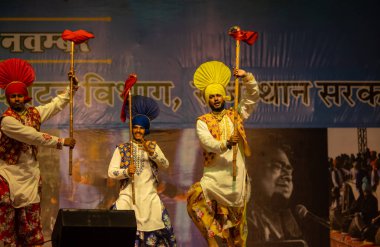 Bikaner, Rajasthan, Hindistan - 14 Ocak 2023: Punjab 'dan bir grup Punjab sanatçısı bikaner deve festivalinde geleneksel renkli elbiseler içinde bhangra dansı yapıyorlar.