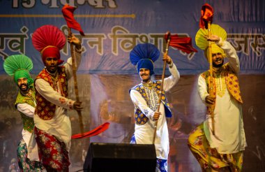 Bikaner, Rajasthan, Hindistan - 14 Ocak 2023: Punjab 'dan bir grup Punjab sanatçısı bikaner deve festivalinde geleneksel renkli elbiseler içinde bhangra dansı yapıyorlar.