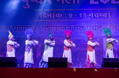 Bikaner, Rajasthan, Hindistan - 14 Ocak 2023: Punjab 'dan bir grup Punjab sanatçısı bikaner deve festivalinde geleneksel renkli elbiseler içinde bhangra dansı yapıyorlar.