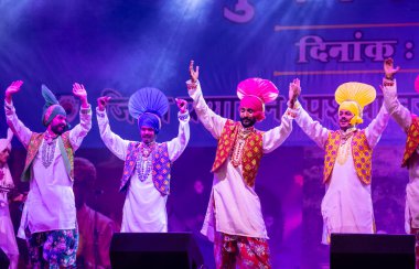 Puşkar, Rajasthan, Hindistan - 11 Kasım 2024: Bhangra, Bhangra grubu, açık hava kültür gecesi renkli etnik elbiseler içinde bhangra dansı yapıyor.