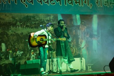 Puşkar, Rajasthan, Hindistan - 11 Kasım 2024: Bhangra, Bhangra grubu, açık hava kültür gecesi renkli etnik elbiseler içinde bhangra dansı yapıyor.