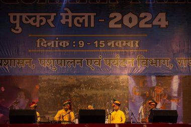 Puşkar, Rajasthan, Hindistan - 11 Kasım 2024: Bhangra, Bhangra grubu, açık hava kültür gecesi renkli etnik elbiseler içinde bhangra dansı yapıyor.