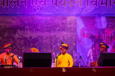 Puşkar, Rajasthan, Hindistan - 11 Kasım 2024: Bhangra, Bhangra grubu, açık hava kültür gecesi renkli etnik elbiseler içinde bhangra dansı yapıyor.