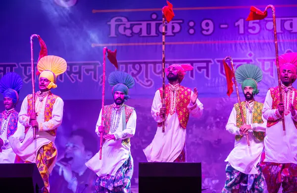 Bikaner, Rajasthan, Hindistan - 14 Ocak 2023: Punjab 'dan bir grup Punjab sanatçısı bikaner deve festivalinde geleneksel renkli elbiseler içinde bhangra dansı yapıyorlar.