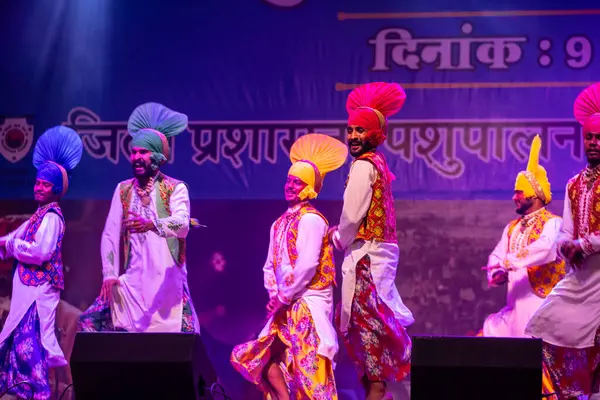 Pushkar, Rajasthan, Hindistan - 11 Kasım 2024: Bhangra, Sih erkek sanatçılar grubu renkli etnik elbiseler içinde bhangra dansı yapıyorlar..