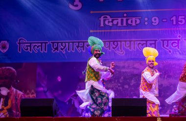 Puşkar, Rajasthan, Hindistan - 11 Kasım 2024: Bhangra, Bhangra grubu, açık hava kültür gecesi renkli etnik elbiseler içinde bhangra dansı yapıyor.