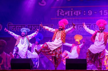 Puşkar, Rajasthan, Hindistan - 11 Kasım 2024: Bhangra, Bhangra grubu, açık hava kültür gecesi renkli etnik elbiseler içinde bhangra dansı yapıyor.