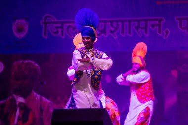 Puşkar, Rajasthan, Hindistan - 11 Kasım 2024: Bhangra, Bhangra grubu, açık hava kültür gecesi renkli etnik elbiseler içinde bhangra dansı yapıyor.