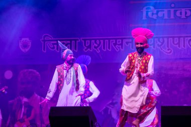 Puşkar, Rajasthan, Hindistan - 11 Kasım 2024: Bhangra, Bhangra grubu, açık hava kültür gecesi renkli etnik elbiseler içinde bhangra dansı yapıyor.