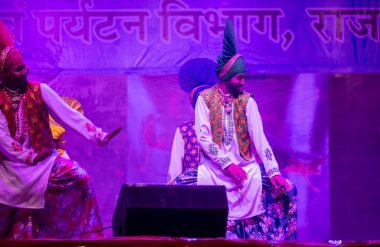 Puşkar, Rajasthan, Hindistan - 11 Kasım 2024: Bhangra, Bhangra grubu, açık hava kültür gecesi renkli etnik elbiseler içinde bhangra dansı yapıyor.