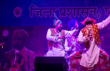 Puşkar, Rajasthan, Hindistan - 11 Kasım 2024: Bhangra, Bhangra grubu, açık hava kültür gecesi renkli etnik elbiseler içinde bhangra dansı yapıyor.