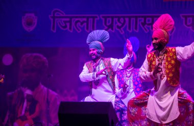 Puşkar, Rajasthan, Hindistan - 11 Kasım 2024: Bhangra, Bhangra grubu, açık hava kültür gecesi renkli etnik elbiseler içinde bhangra dansı yapıyor.
