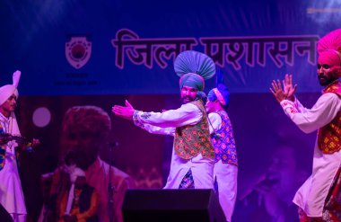 Puşkar, Rajasthan, Hindistan - 11 Kasım 2024: Bhangra, Bhangra grubu, açık hava kültür gecesi renkli etnik elbiseler içinde bhangra dansı yapıyor.