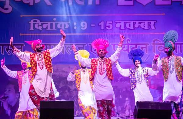 Puşkar, Rajasthan, Hindistan - 11 Kasım 2024: Bhangra, Bhangra grubu, açık hava kültür gecesi renkli etnik elbiseler içinde bhangra dansı yapıyor.