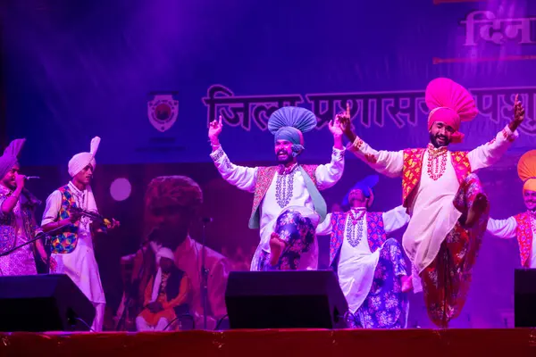 Puşkar, Rajasthan, Hindistan - 11 Kasım 2024: Bhangra, Bhangra grubu, açık hava kültür gecesi renkli etnik elbiseler içinde bhangra dansı yapıyor.
