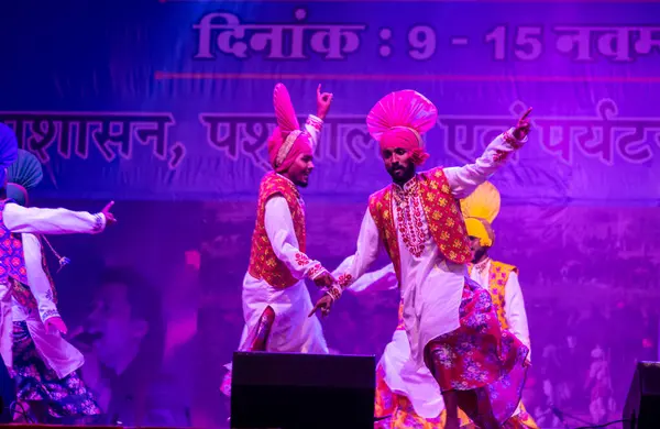 Puşkar, Rajasthan, Hindistan - 11 Kasım 2024: Bhangra, Bhangra grubu, açık hava kültür gecesi renkli etnik elbiseler içinde bhangra dansı yapıyor.