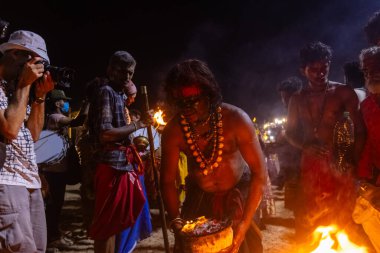 Kulashekharapatnam, Tamilnadu, Hindistan - 11 Ekim 2024: Hint Hindu dindar, yüzü boyalı ve tarikat karakteri gibi giyinmiş, kulasai dasara festivalini akşam ateşle gerçekleştirmek için.