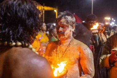 Kulashekharapatnam, Tamilnadu, Hindistan - 11 Ekim 2024: Hint Hindu dindar, yüzü boyalı ve tarikat karakteri gibi giyinmiş, kulasai dasara festivalini akşam ateşle gerçekleştirmek için.